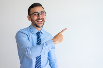 Excited entrepreneur in glasses pointing aside and laughing. Cheerful successful business trainer...
