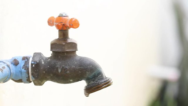 Faucet dripping water drops