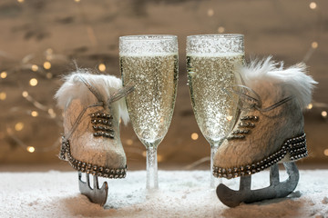 two glasses of champagne and skates in snow