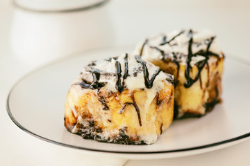 Cinnamon rolls with glaze on a plate. Fresh homemade cinnamon buns.