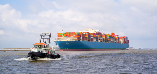 Containerschiff und Schlepper auf der Elbe bei Hamburg, Deutschland