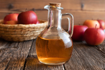 Obraz na płótnie Canvas A bottle of apple cider vinegar with fresh apples