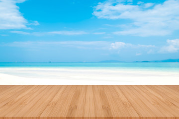 Perspective brown wooden table on top over blur sea in sunny day background. Beautiful sea and clouds in Thailand on summer, can be used mock up for montage products display or design layout.