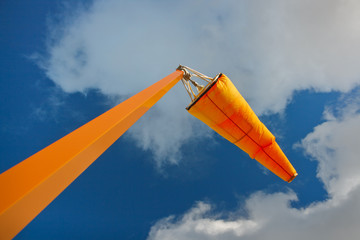 Orange airport windsock and sky.