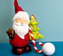 Santa Claus is playing golf with candy cane as golf club. Christmas and New Year holiday background concept. Copy space for text.