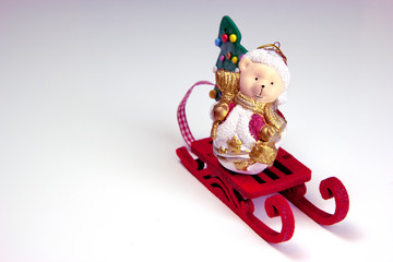 Funny polar bear wearing as Santa Claus and Christmas tree are on the red sled. Christmas and New Year holiday background concept. Copy space for text.