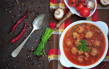 Portion of tomato soup with meatballs 
