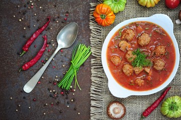 Portion of tomato soup with meatballs 