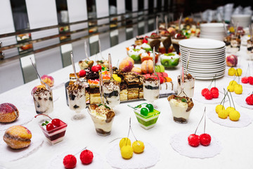 Modern desserts, cupcakes, sweets with fruits. Delicious candy bar. Catering Concept.