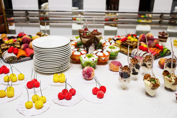 Modern desserts, cupcakes, sweets with fruits. Delicious candy bar. Catering Concept.