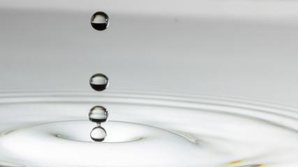 Drops of rain fall into the water, selective focus close-up