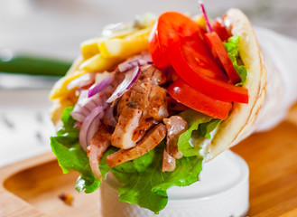 greek lamb meat gyros with tzatziki sauce, vegetables, feta cheese and french fries