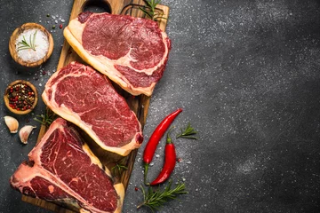 Photo sur Plexiglas Viande Steak de boeuf de viande crue sur la vue de dessus noire.