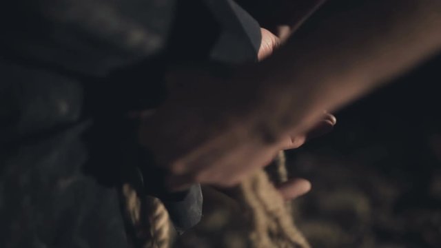 Capture of the hostage. The bandit binds the victim's hand with a rope.