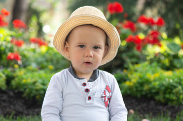 Baby boy sitting on the grass  in the garden on beautiful spring day