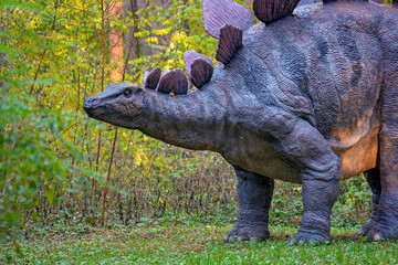 Fototapeta premium Duży model prehistorycznego dinozaura w przyrodzie. Realistyczna sceneria.