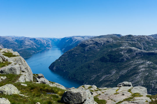 View at lysefjorden from above Preikestolen/Pulpit Rock in Norway with a clear blue sky. Lysefjorden and the Norwegian landscape.