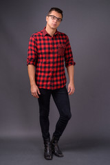 Studio shot of young handsome man against gray background © Ranta Images