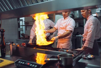 Crédence de cuisine en verre imprimé Cuisinier Fire in the kitchen. Fire gas burn is cooking on iron pan,stir fire very hot