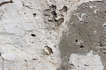 Deteriorating white and grey plastered wall texture background fragment
