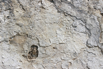 Deteriorating white and grey plastered wall texture background fragment