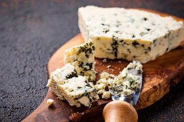 Blue cheese and knife on cutting board