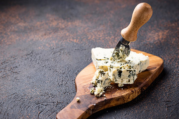 Blue cheese and knife on cutting board