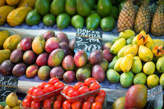 Colorful piles of tropical mangoes, papayas, and other fruits at an outdoor farmers market in Rio de Janeiro, Brazil