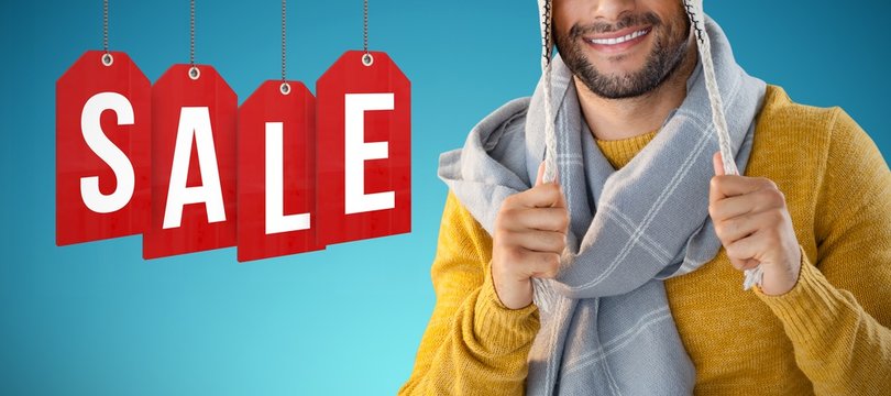 Composite image of portrait of smiling man holding wooly hat