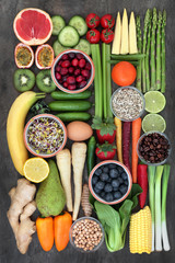 Health food concept for a healthy life with fresh vegetables, fruit, herbs, spices, legumes, seeds and coffee. Foods high in antioxidants, anthocyanins, vitamins and dietary fibre. Flat lay.