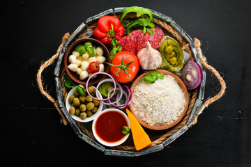 Ingredients for pizza in a wooden box. Top view. On a wooden background. Free copy space.