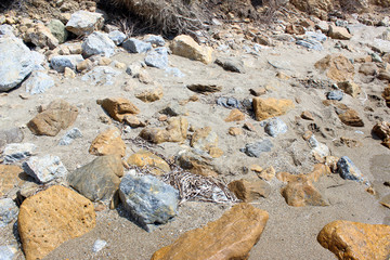 Yellow, grey and white rocks on beach sand horizontal
