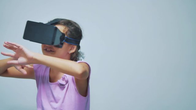 Happy young little girl using 3d goggles a virtual reality headset. Surprised woman with VR device. Happy smiling girl with virtual reality glasses on head. entertainment virtual reality concept