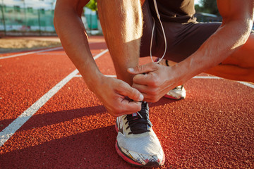 young man runner tying shoelaces
