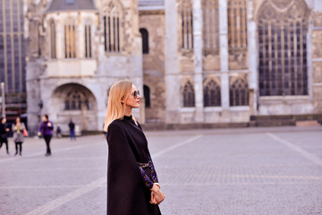 girl in a black coat on the background of the castle
