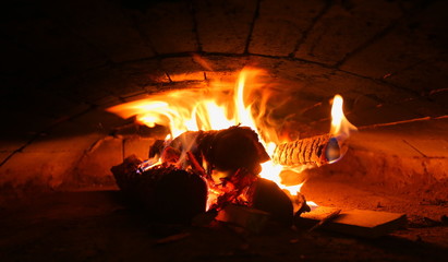 Several burning logs in a brick oven