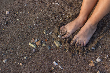 young female feet on sea sand background texture wallpaper pattern concept and empty copy space