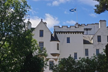 Fototapeta na wymiar Blair Athol, Scotland: The flag of Scotland flies over Blair Castle, a 13th-century stronghold in the Scottish Highlands.