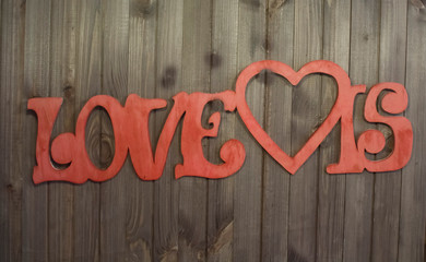 love is inscription with a heart on a wooden background