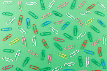 Background made from colored paper clips on the light green base