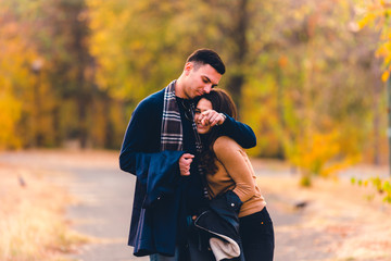 Couple hugging and pointing in some direction.