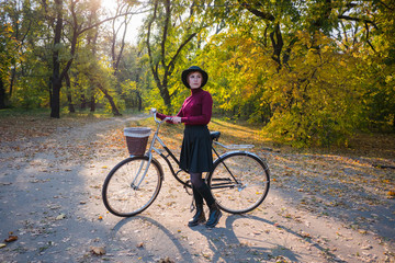 Obraz premium young woman riding on retro bicycle in the autumn park 