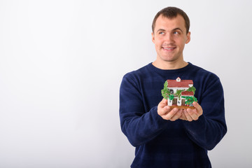 Studio shot of young happy muscular man smiling and thinking whi