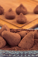Preparation of chocolates, dip truffles in cocoa powder.