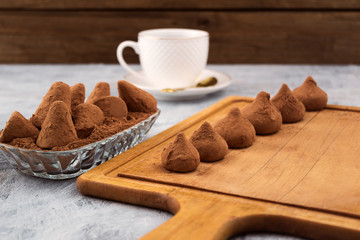 Chocolate truffles in powder from cocoa powder, stacked on a wooden Board.