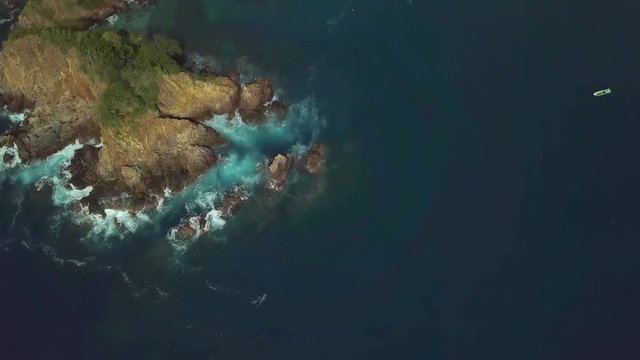 Aerial view to rocky island and deep blue ocean