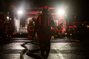 Firefighter walking on a building fire emergency