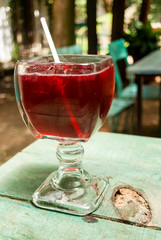 Cup with Rosa de Jamaica drink on outdoor table, restaurant in Guatemala, Central America.