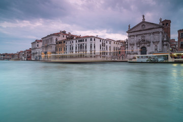 View on grand canal with passing by boat  in Venice and San Stae at sunset,long exposure photo.