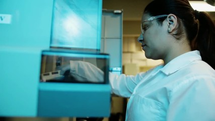 A handheld shot of a researcher checking a DNA sequencer a genetic laboratory at university  - Powered by Adobe